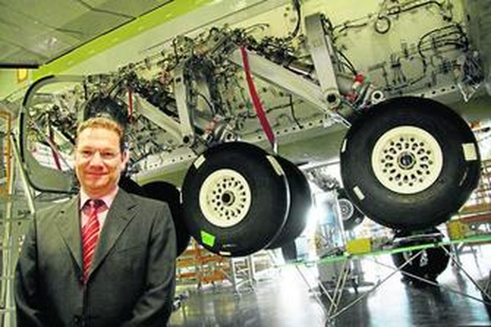 Arturo Lammers, bajo el fuselaje y junto a las enormes ruedas del cuarto avión que se monta en San Pablo.