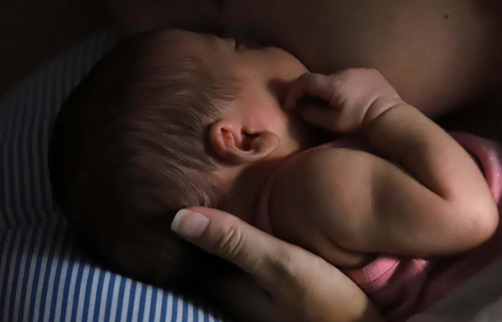 Una madre sostiene a su bebé recién nacido.