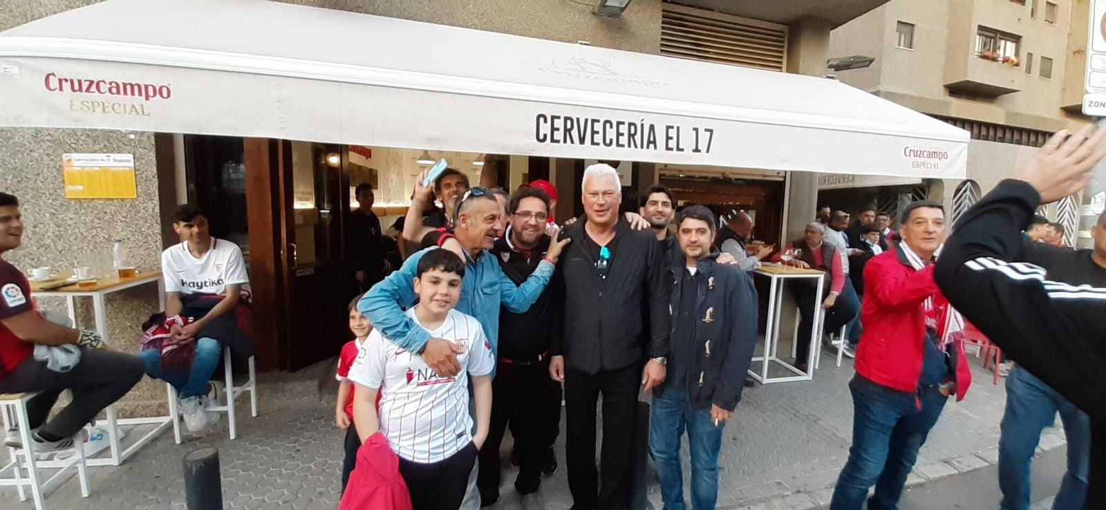 Toni Polster posa con varios aficionados del Sevilla después del derbi que presenció en 2022.