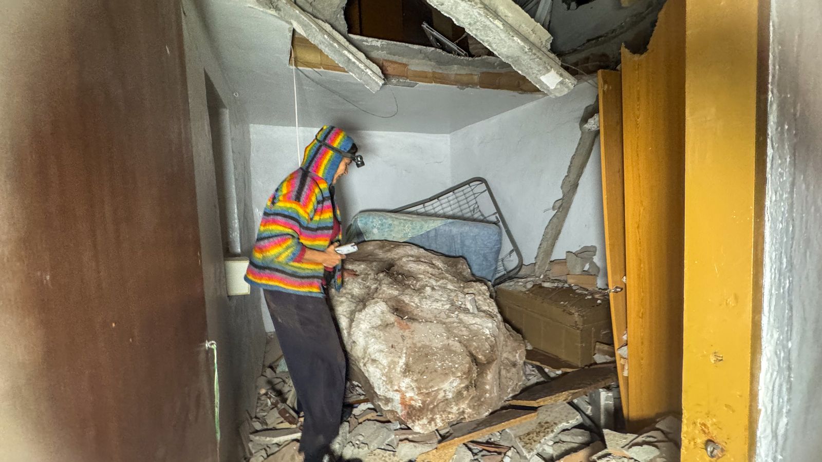 Una de las vecinas en el interior de la habitación destrozada por una gran piedra