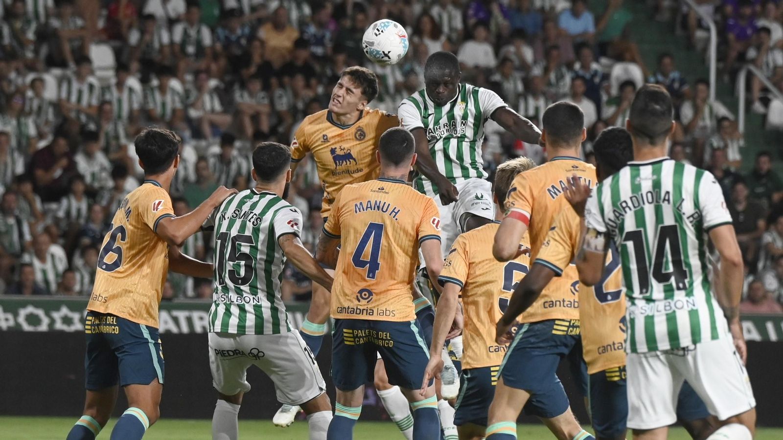 Fomeyem, central del Córdoba CF, remata el balón sobre la defensa del Racing de Santander.