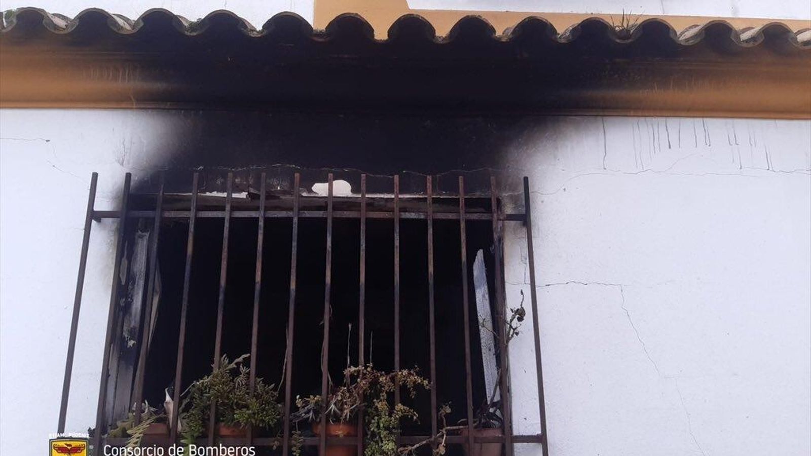 Ventana de la vivienda por donde salían las llamas.