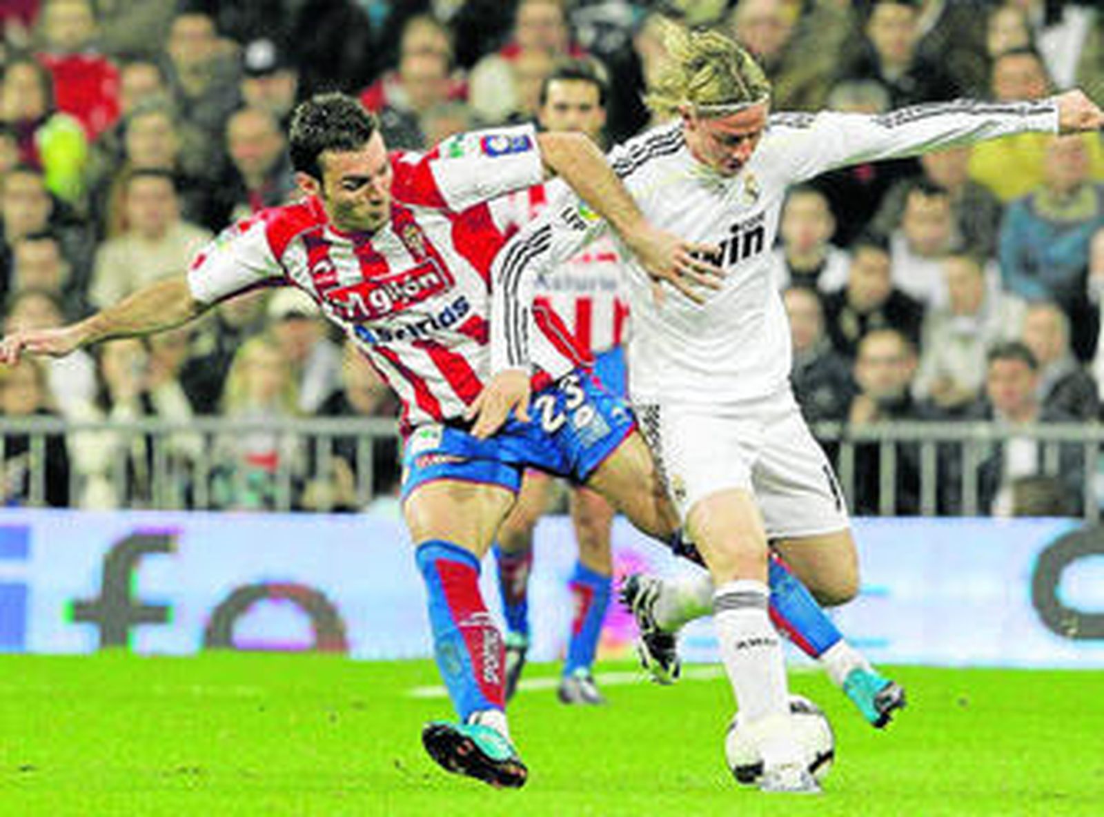Guti protege el balón ante la presión del isleño Barral.