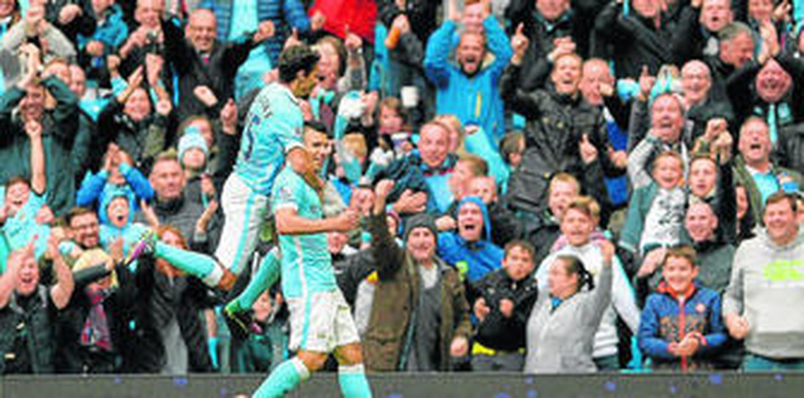 El extremo sevillano Jesús Navas se encarama en Sergio Agüero, que acaba de hacer el tercero de sus cinco goles al Newcastle.