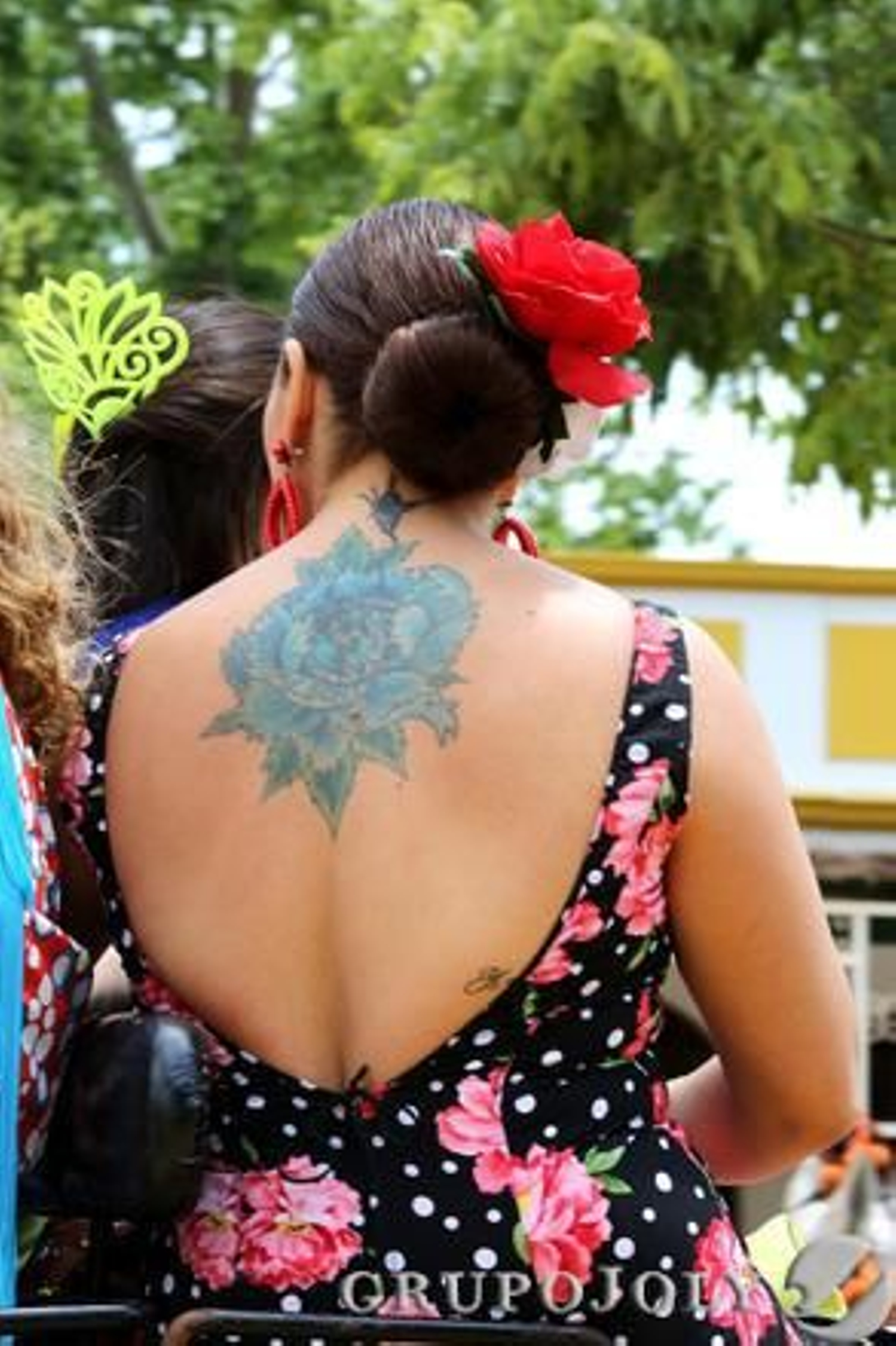 Una mujer vestida de flamenca muestra su tatuaje de la espalda.

Foto: Pascual