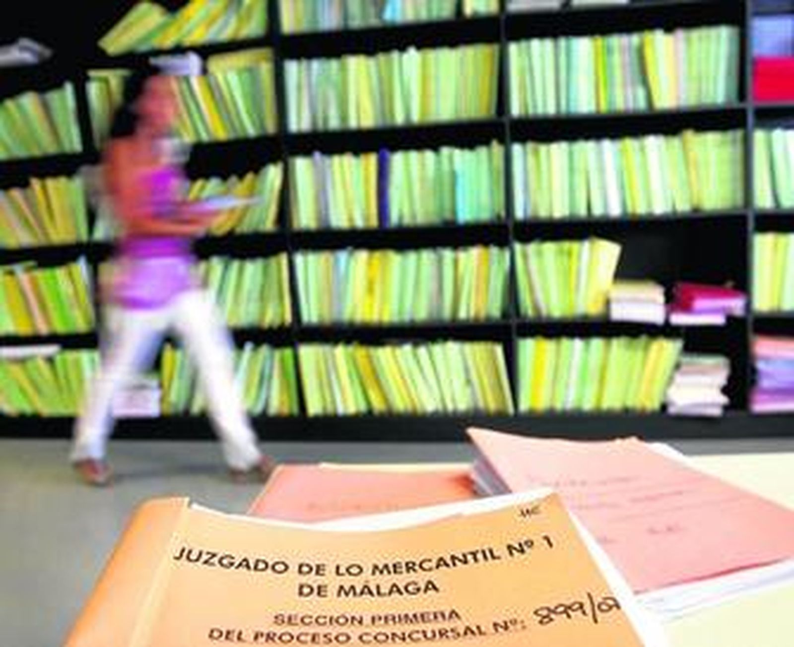 Una funcionaria pasa ante una estantería con procedimientos en el Juzgado de lo Mercantil número 1.