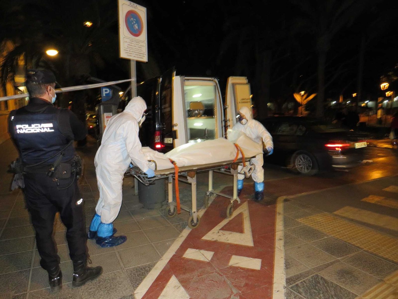 Agentes introducen el cuerpo en el vehículo funerario.