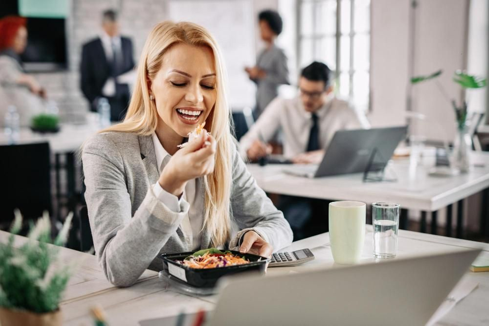 Mujer comiendo en el trabajo.