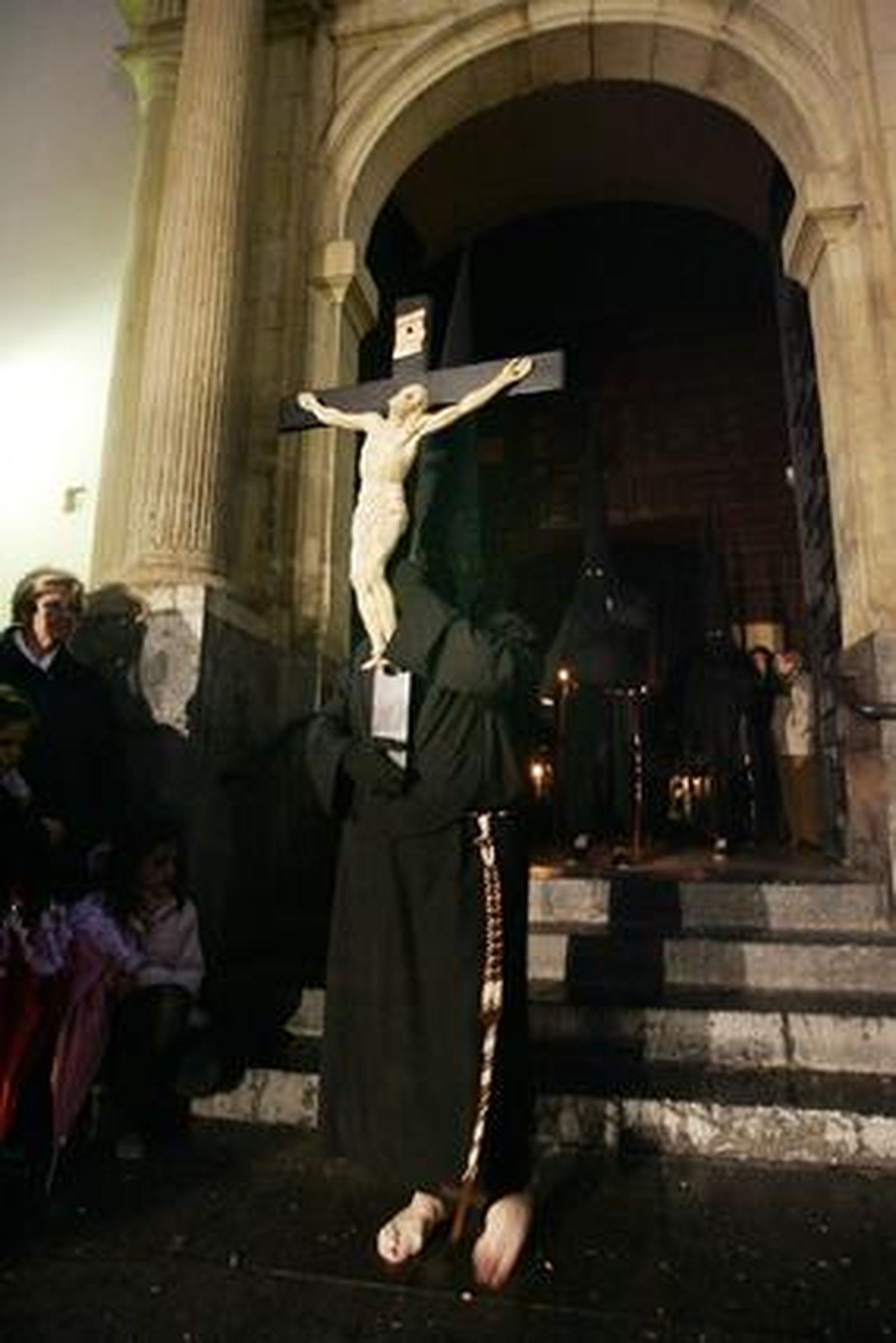 Un nazareno porta singular cruz de guía de la cofradía. / Óscar Barrionuevo