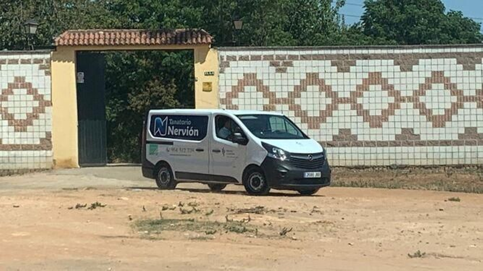 Un furgón  funerario sale del escenario de los hechos