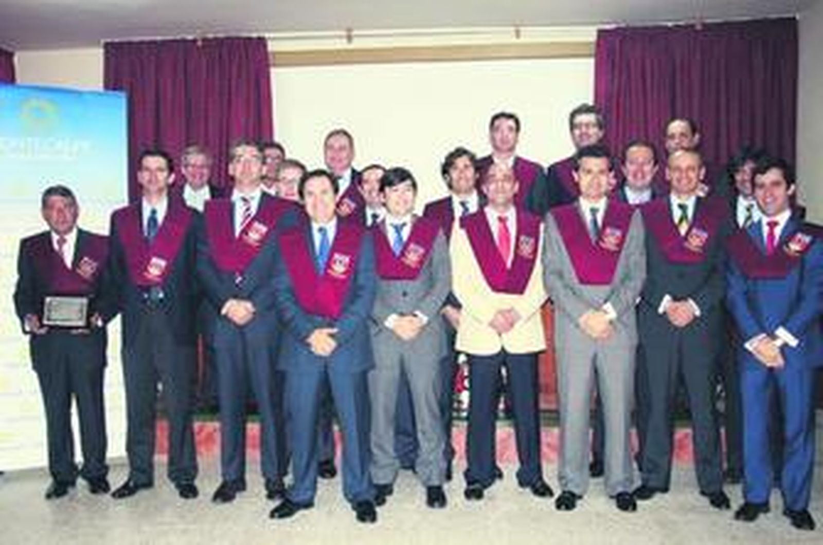 Profesores y antiguos alumnos posan tras la imposición de becas.