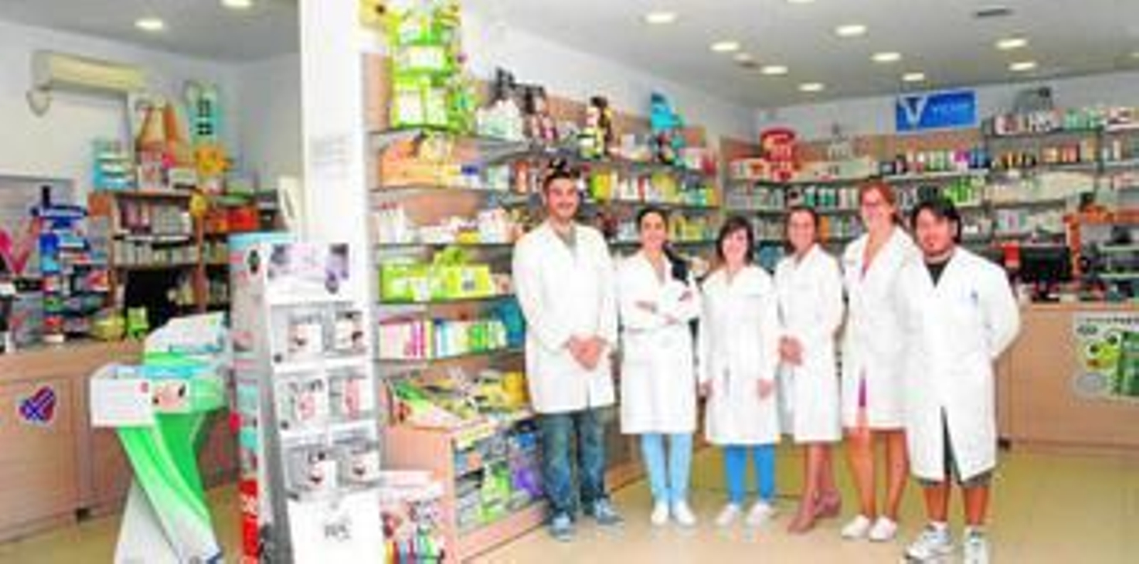 Concha Rodríguez, tercera por la derecha, acompañada de varios de los trabajadores de la farmacia.