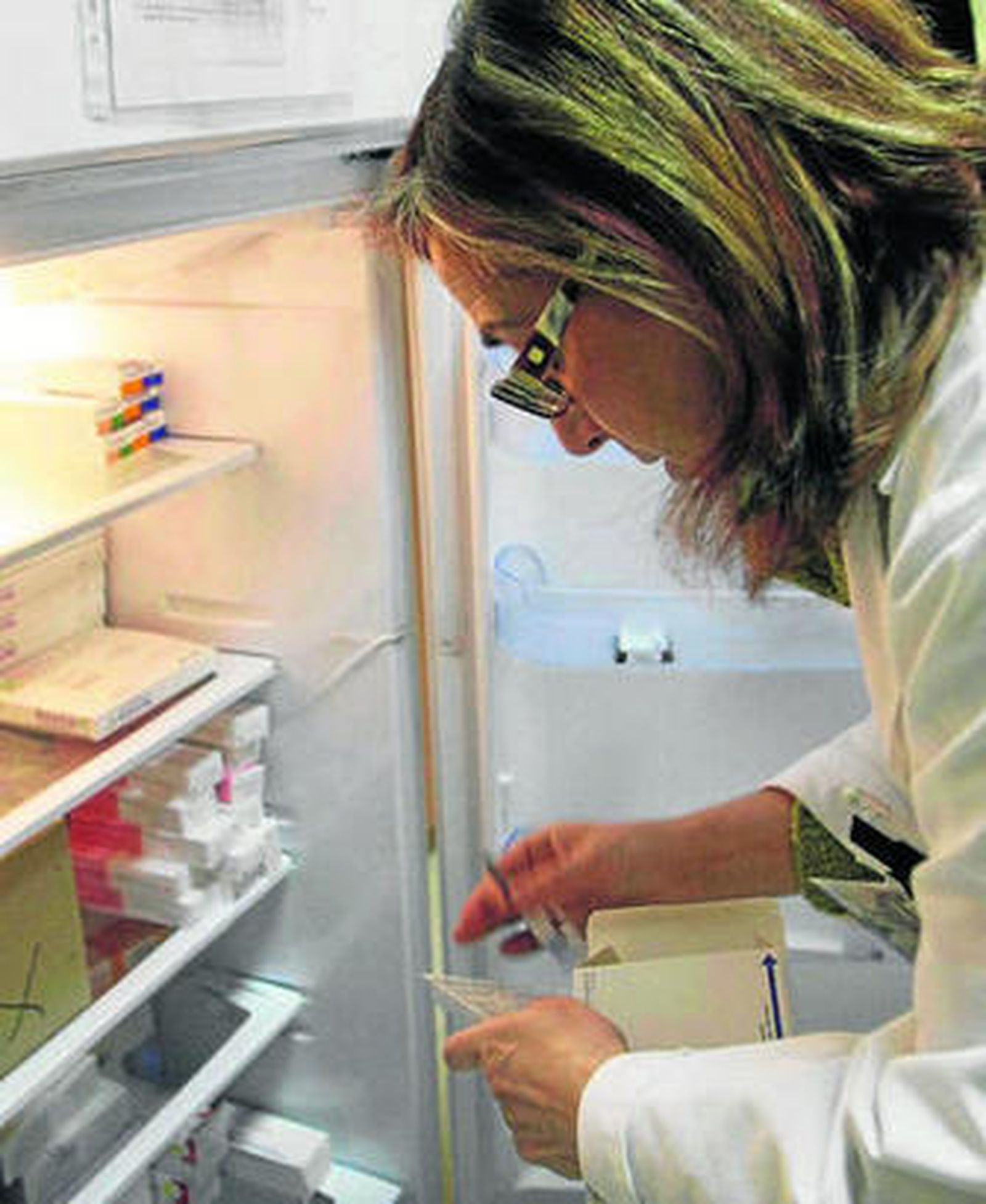 Una sanitaria busca vacunas en una nevera.