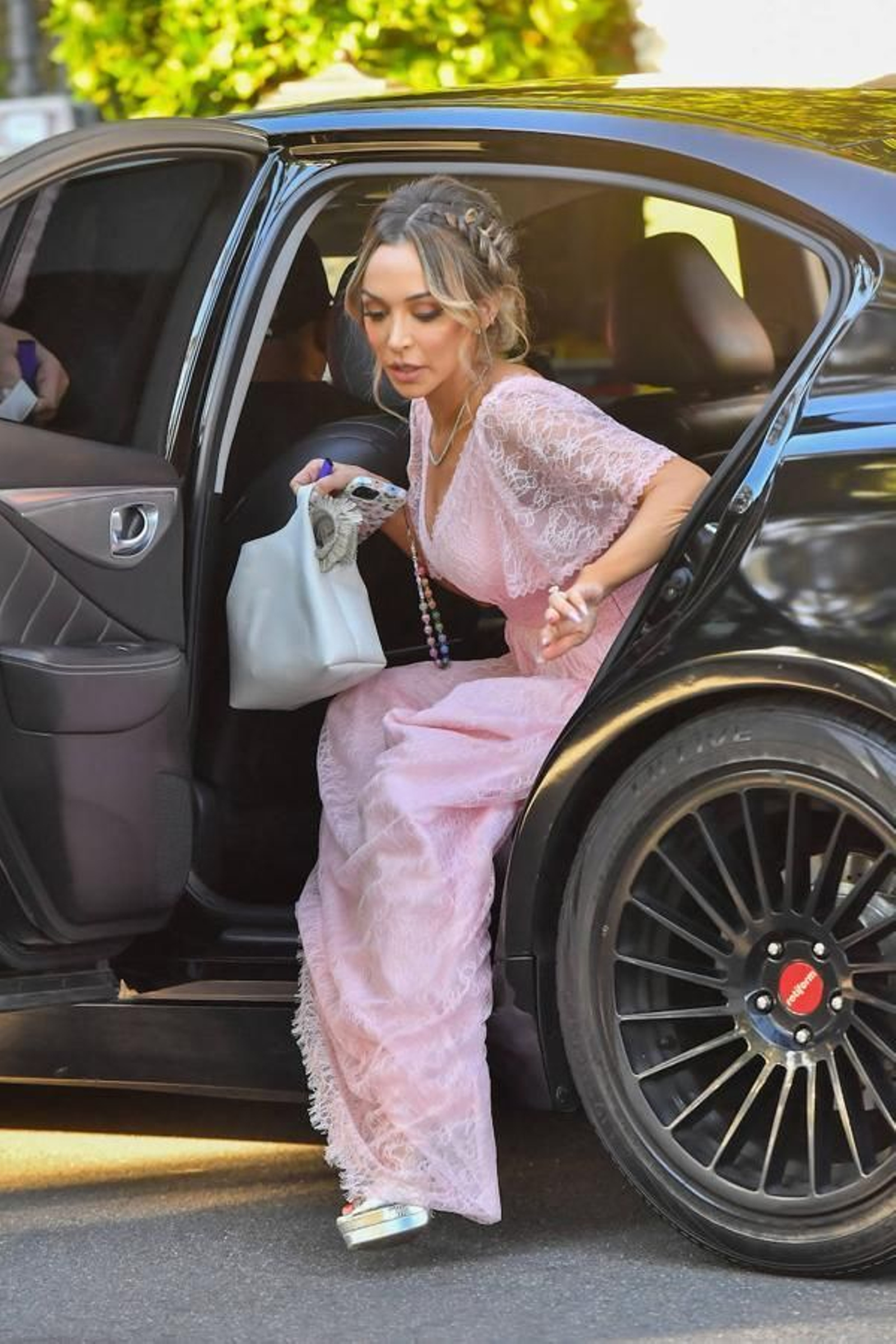 Una de las damas de honor, vestida de rosa, llega al lugar de la ceremonia.