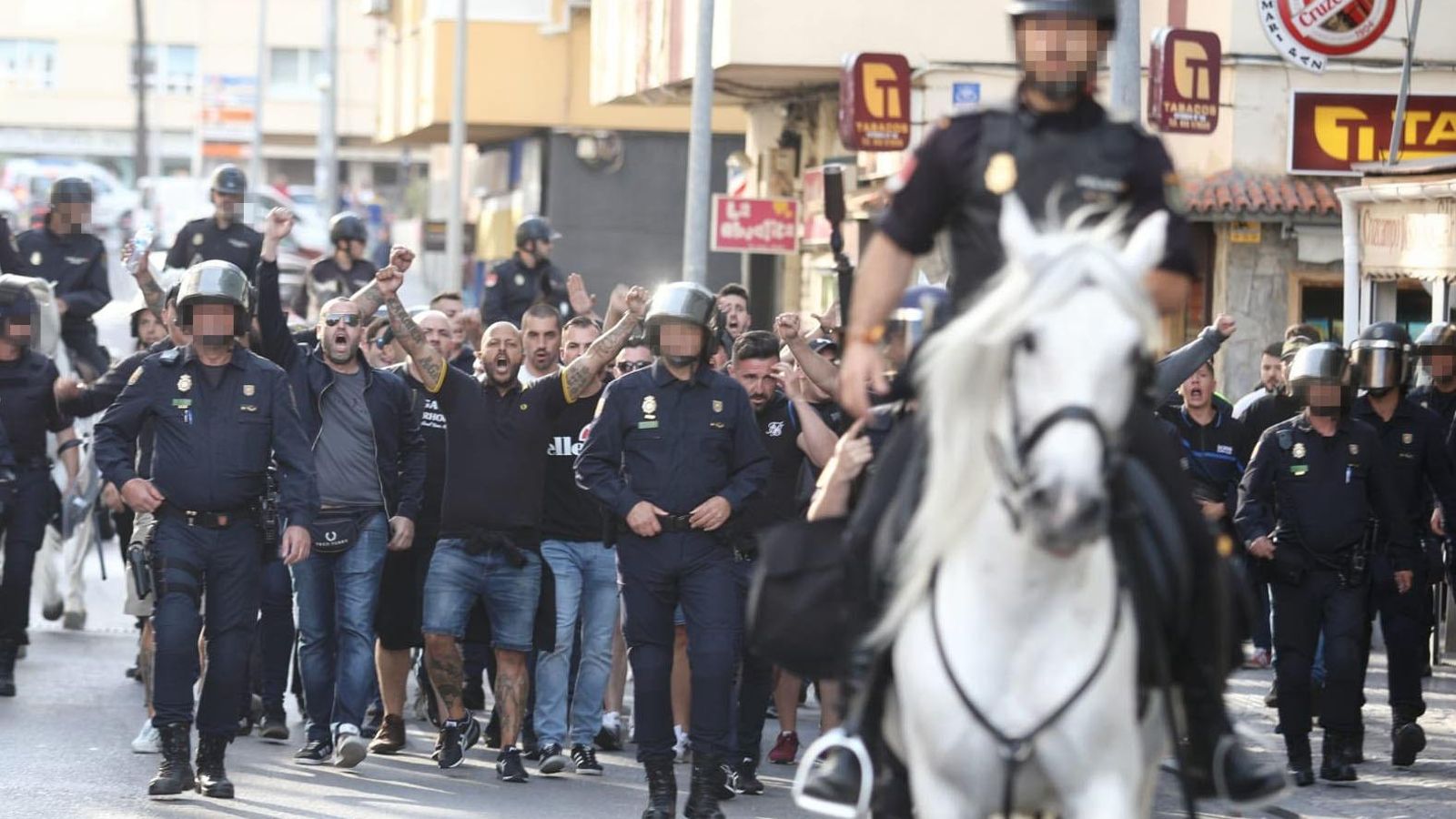 Agentes de la Policía Nacional acompañan a los ultras del Málaga en los aledaños del estadio Carranza.