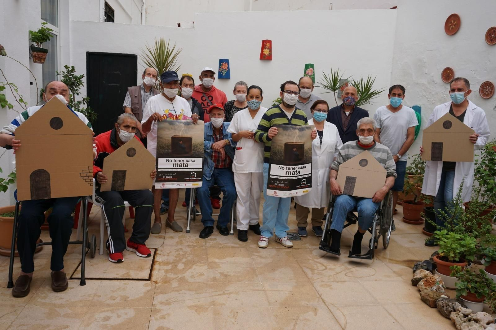 Residentes del Hogar Pozos Dulces con el cartel de la campaña.