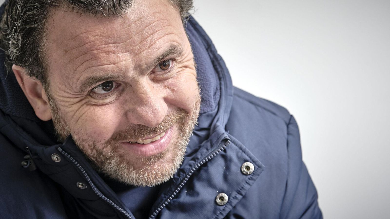 El entrenador cadista sonríe en el transcurso de la entrevista.