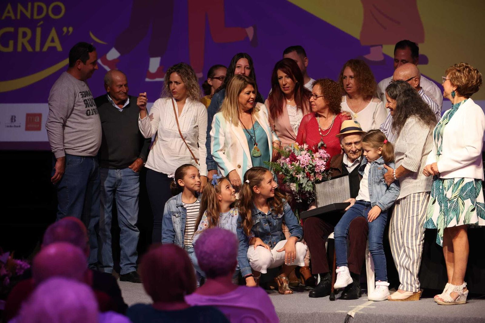 Antonio Barea, rodeado de su familia, tras recibir una distinción de manos de Mamen Sánchez.