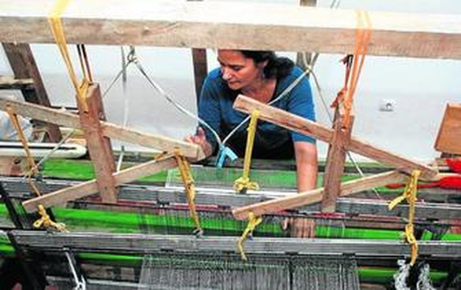La educadora y artesana Ara Pavón tejiendo con el telar.