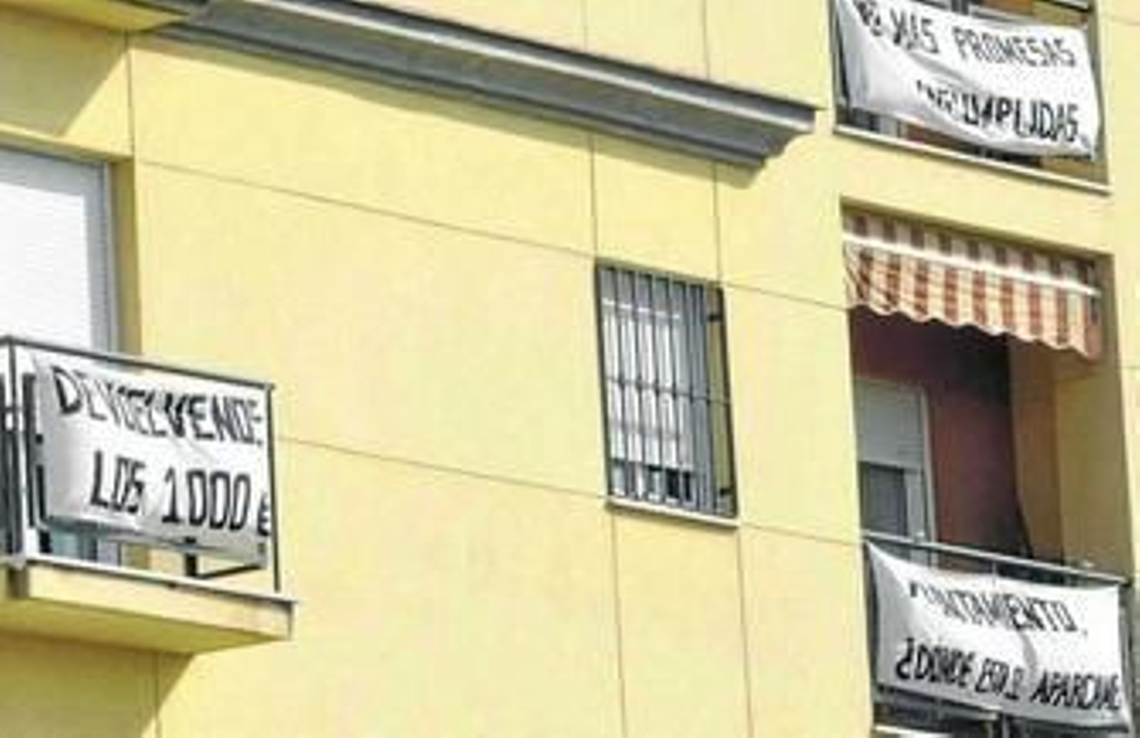 Pancartas de protesta, en balcones junto a Santa Justa, para exigir la devolución del dinero entregado para el aparcamiento de Pedro Vallina.