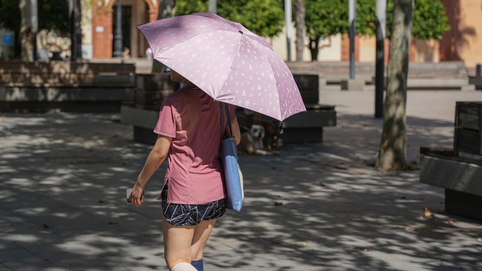 Una mujer con sombrilla y ropa veraniega