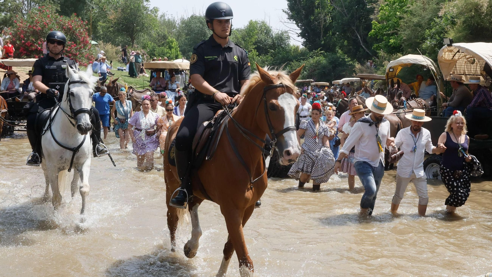 Guardias civiles acompañan a una de las hermandades del Rocío cruzando el Quema, este martes.