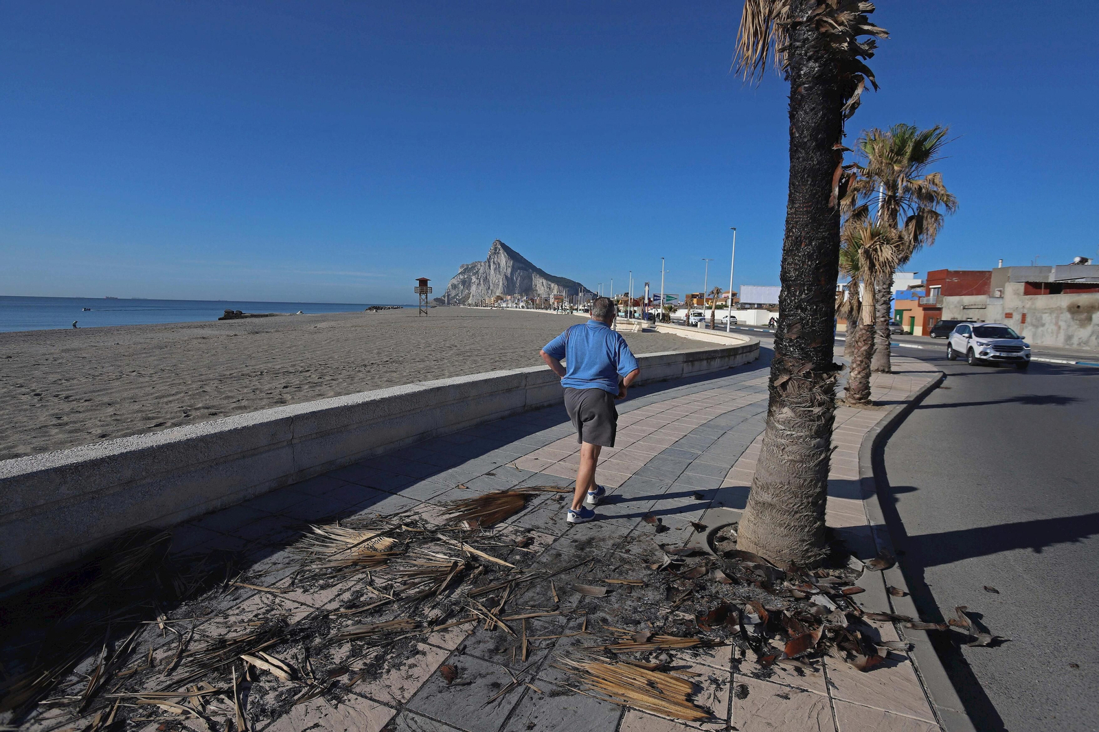 Un hombre hace deporte junto a los restos de un incendio.