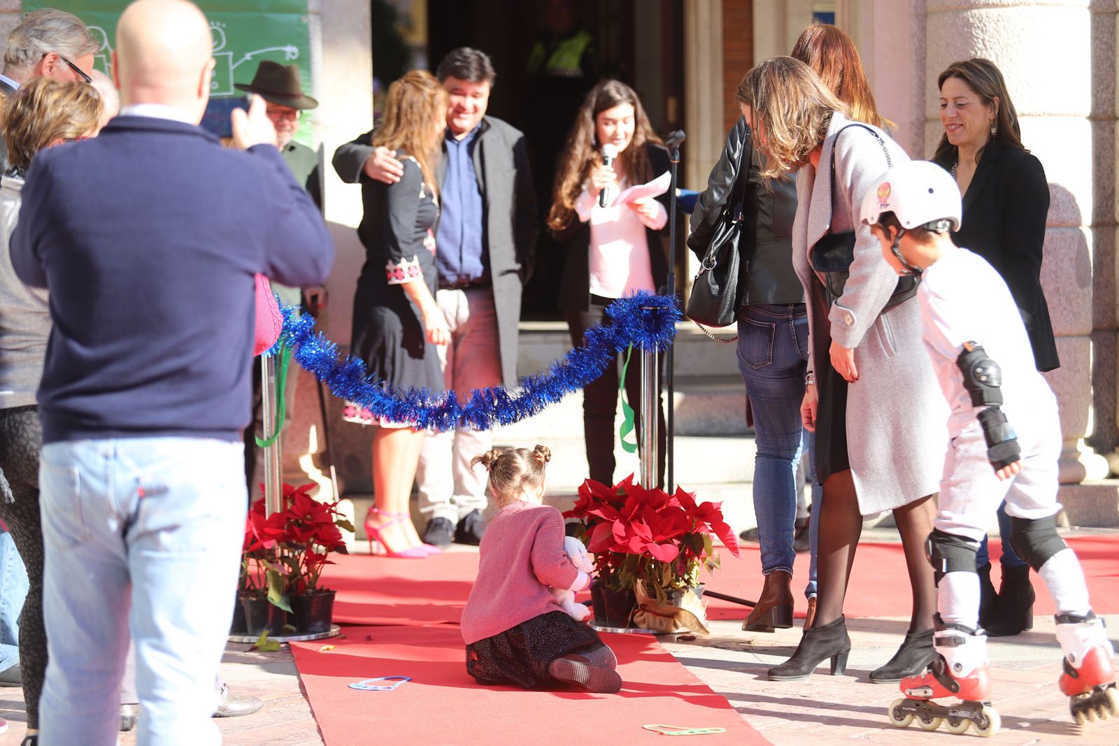 Una niña deposita euros en la alfombra roja.