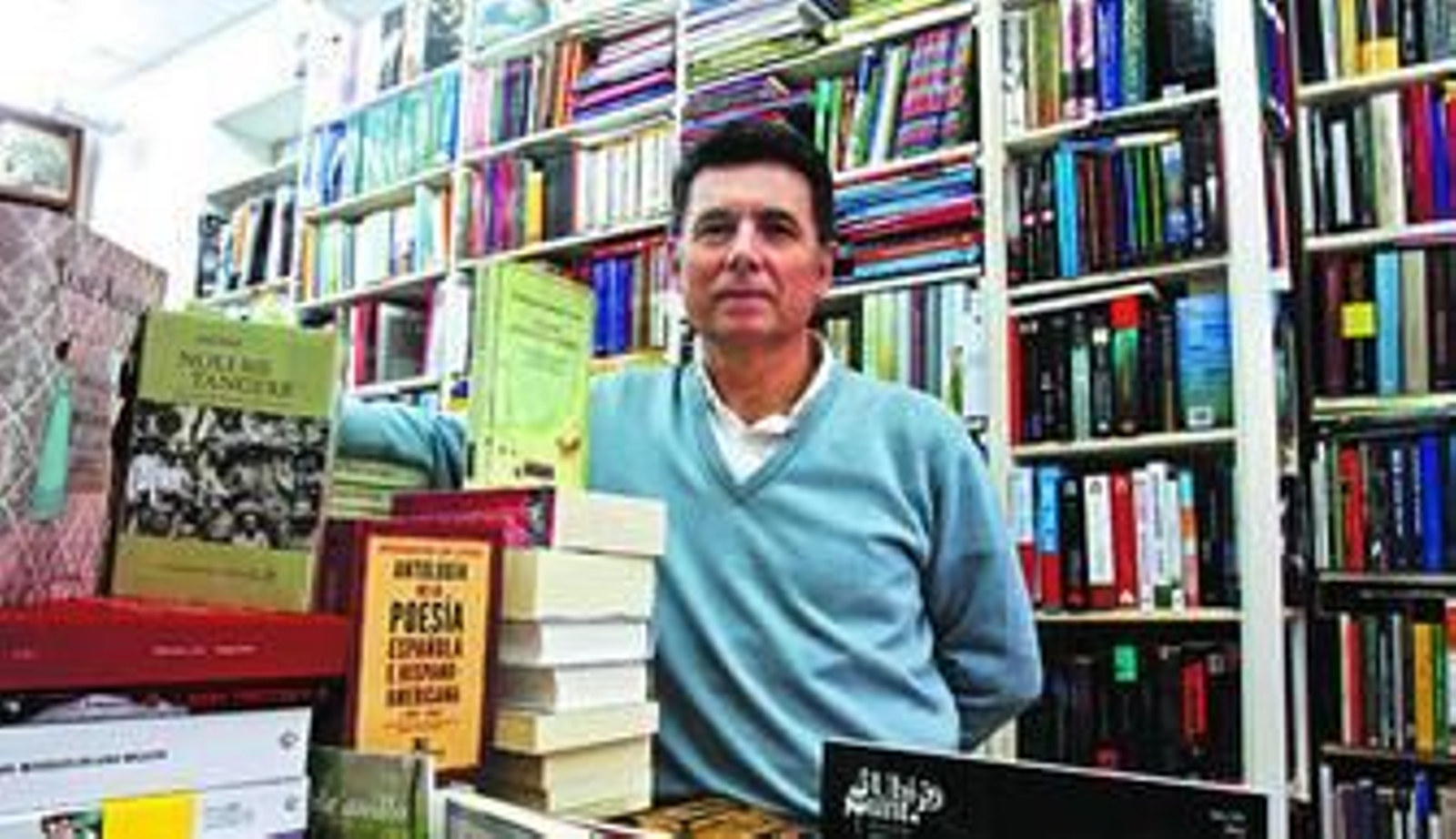 Juan Manuel Fernández posa entre los volúmenes de su librería Manuel de Falla.