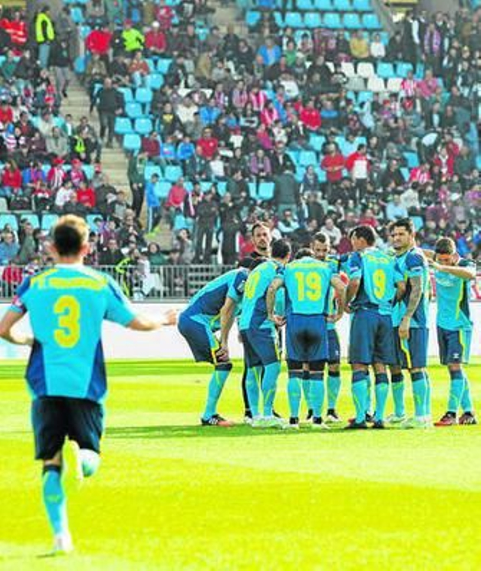 Fernando Navarro corre para unirse al corro habitual antes del partido.