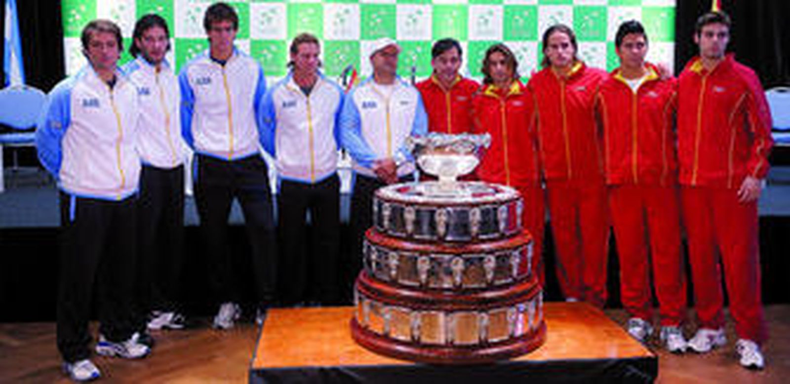 Los integrantes de ambos equipos, con sus respectivos capitanes al frente, posan delante del trofeo que este fin de semana levantarán cinco de ellos.