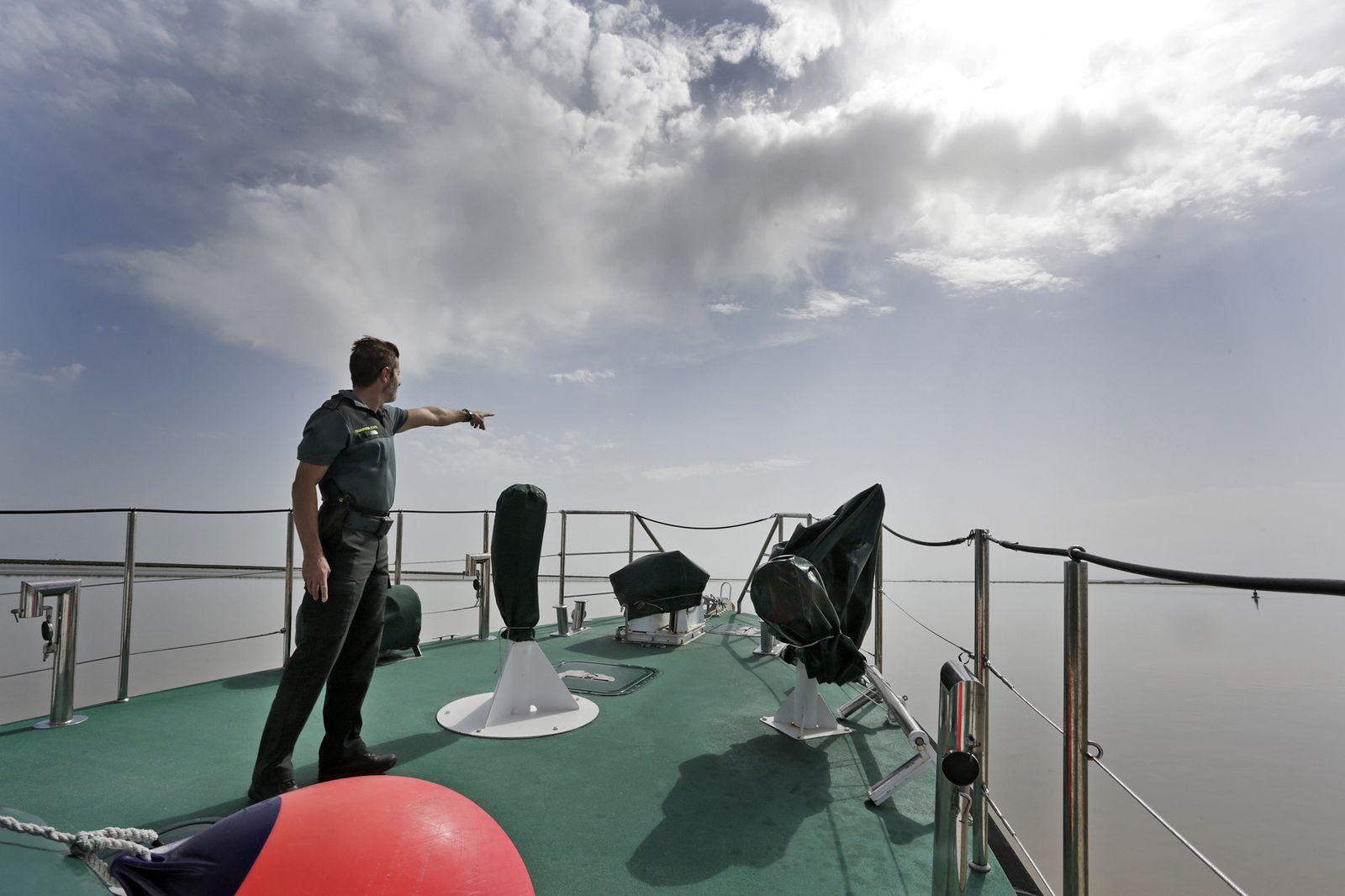 Uno de los agentes de la patrulla marítima señala el lugar por donde se introducen las gomas de los contrabandistas.