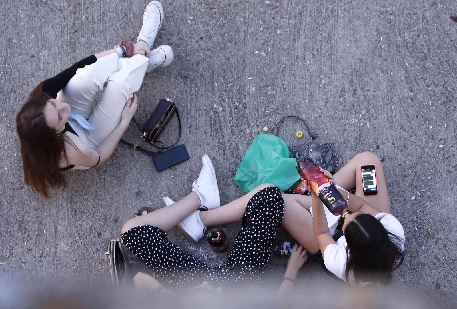 Varias jóvenes bebiendo en la calle.
