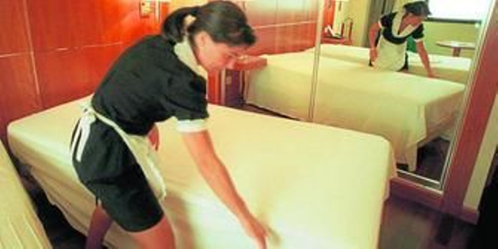 Una camarera de hotel prepara una de las habitaciones para los clientes.