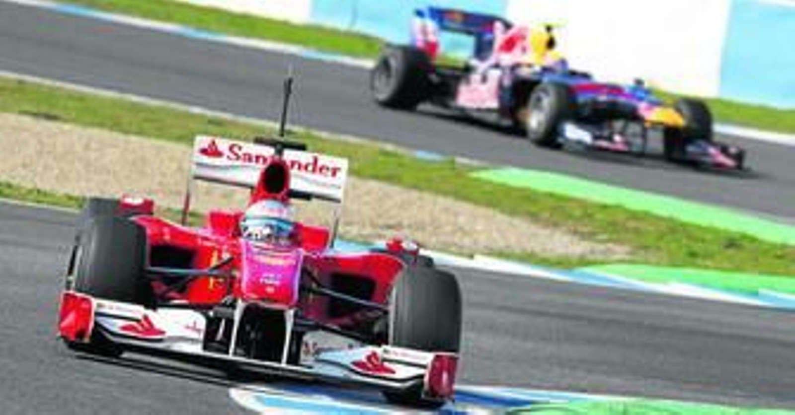 Fernando Alonso 'pasa' por la chicane del Circuito de Jerez mientras que al fondo se adivina la estela del Red Bull de Mark Webber.