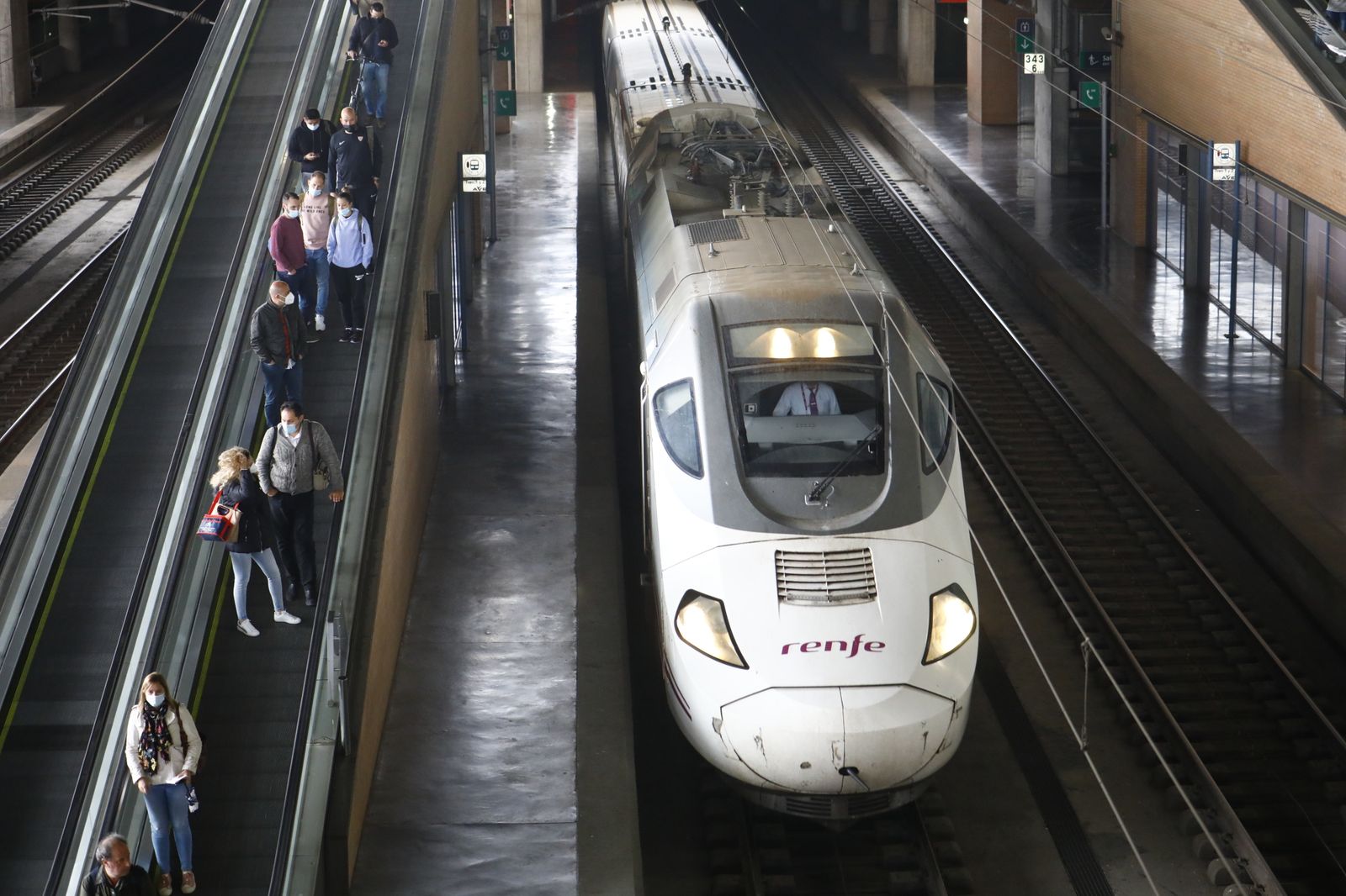 Un AVE hace su entrada en la Estación de Córdoba, con un grupo de viajeros en busca del andén.