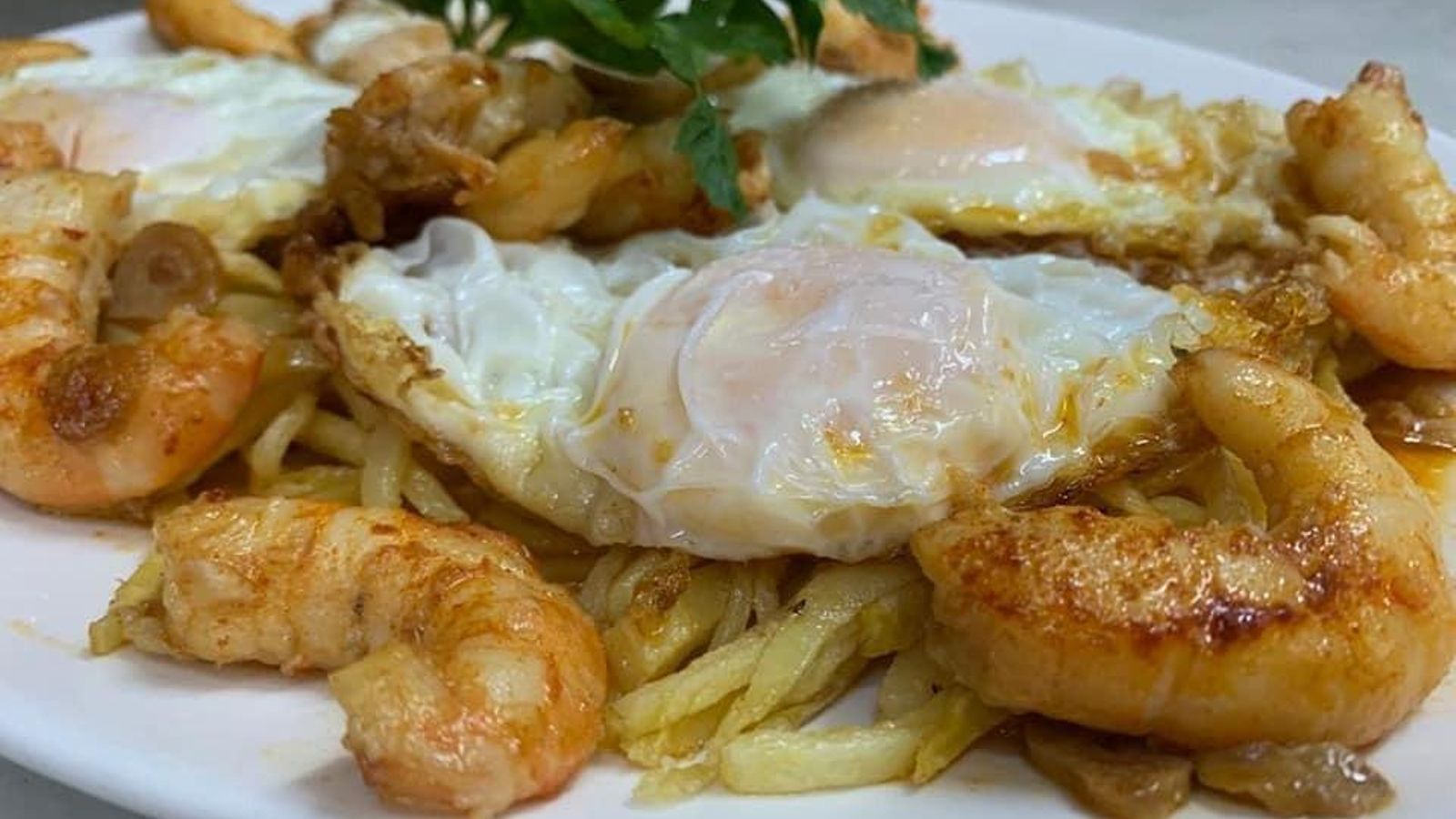 Patatas con huevos fritos y gambas