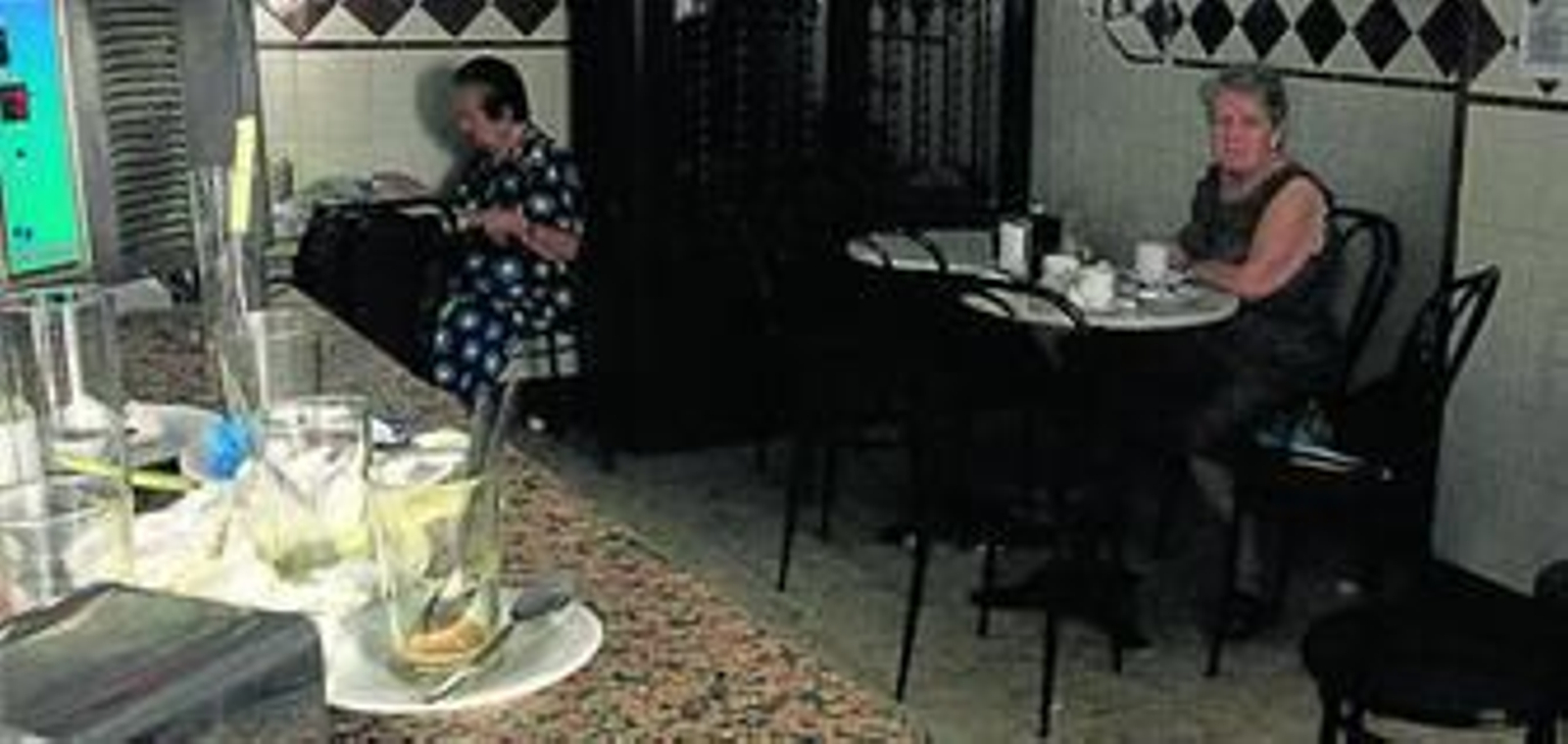 Dos mujeres desayunan a oscuras en una cafetería del barrio de La Viña.