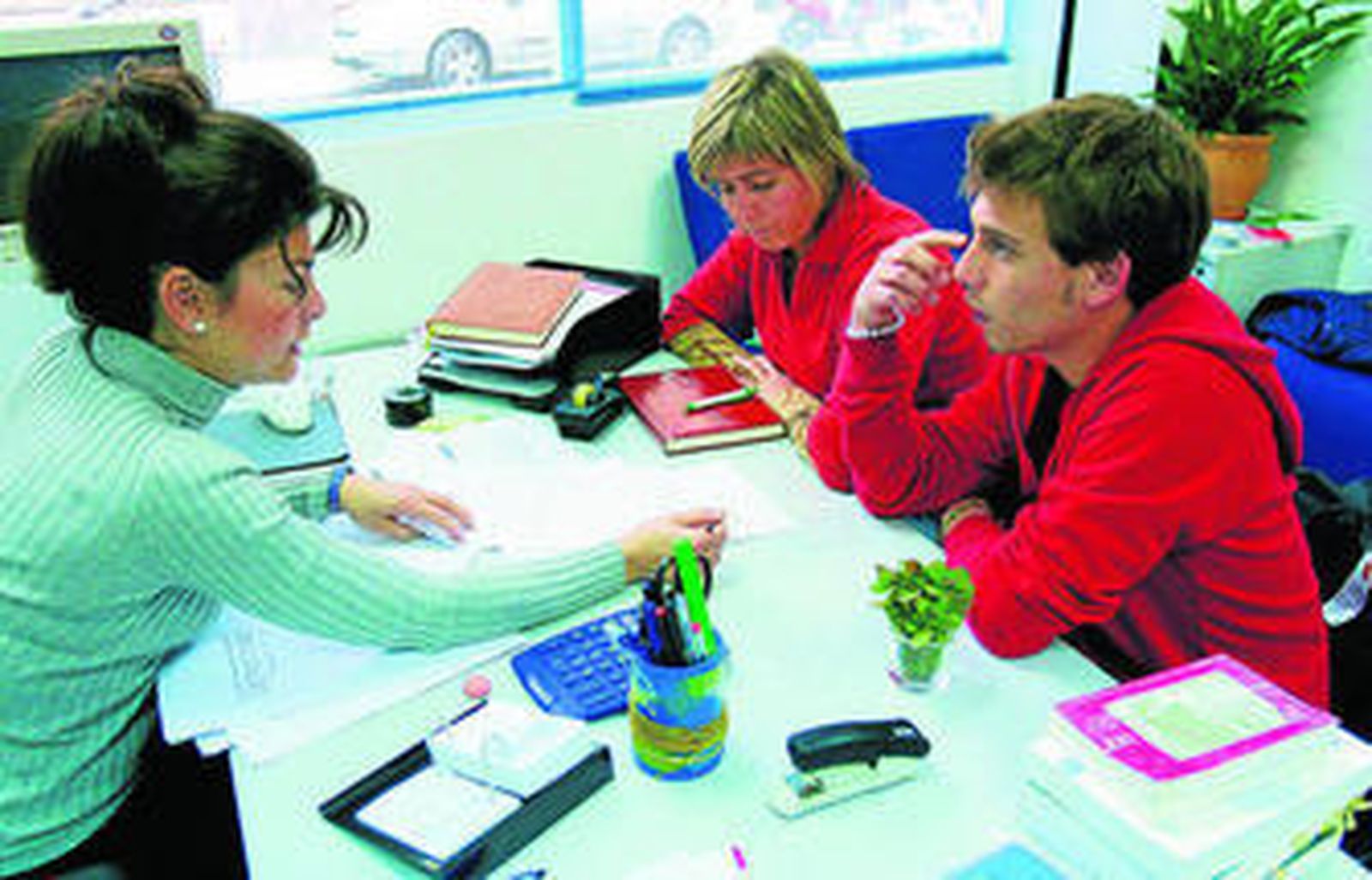 Orientadora del IMFE atiende a dos personas en su oficina.