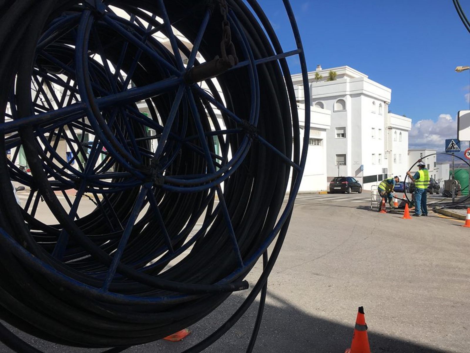 Dos operarios instalan cables de fibra óptica.