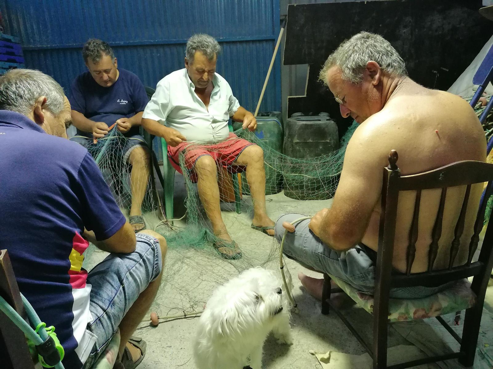 Pescadores arreglan en la jornada anterior sus redes para sacarlas al mar