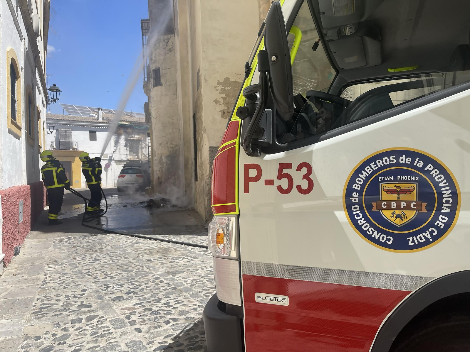 Bomberos refrescando la fachada junto a la que se produjo el incendio.
