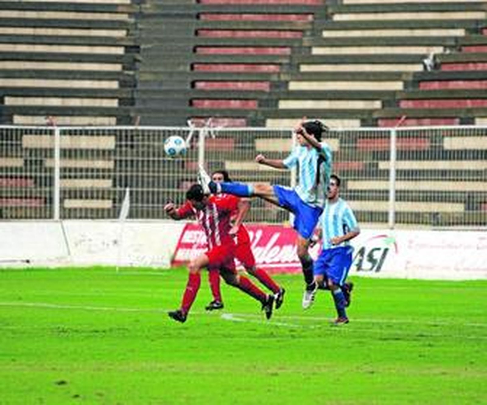 Un jugador del Malagueño despeja de manera acrobática en el partido contra el Almería B.