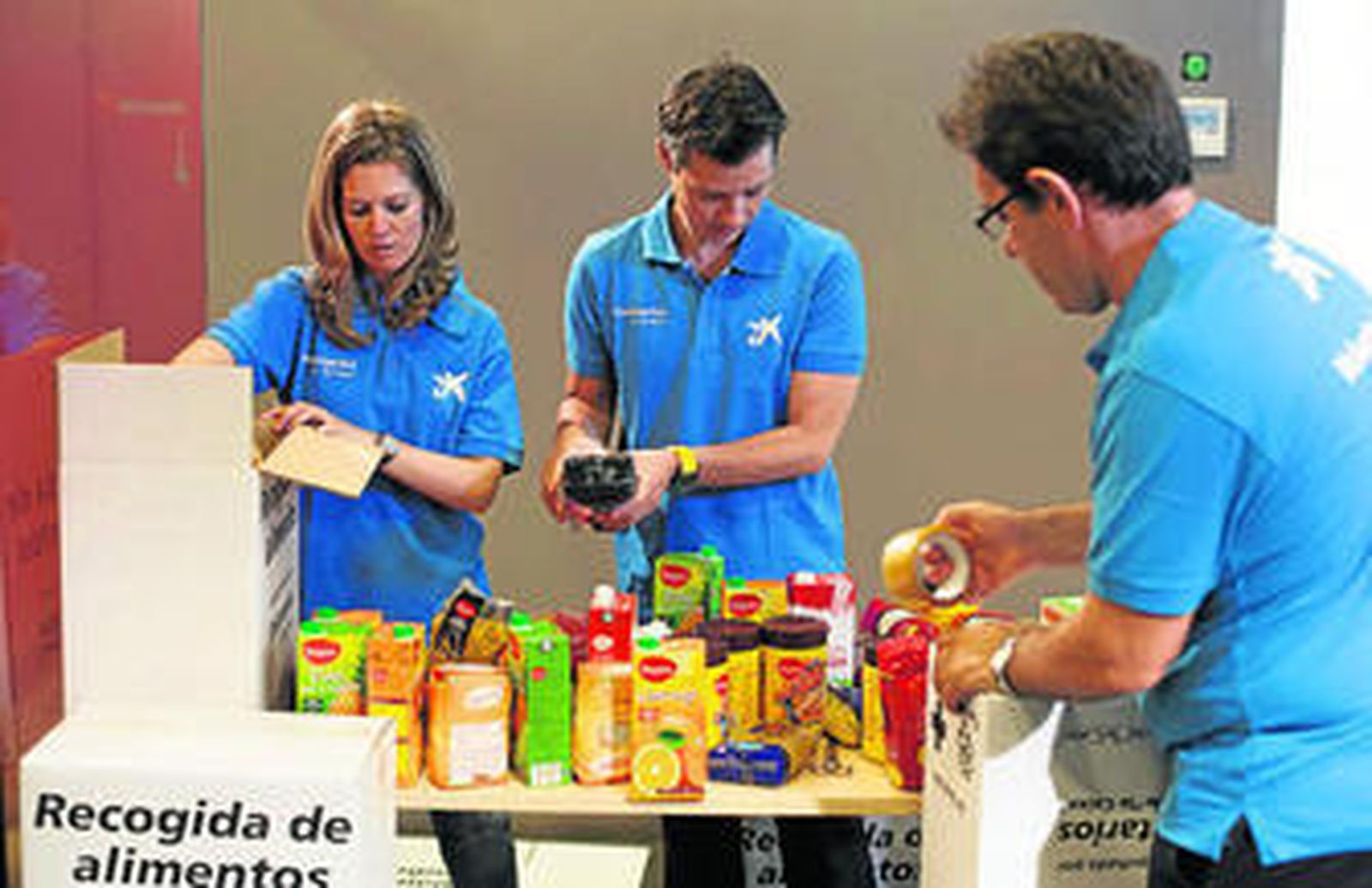 Voluntarios de la Obra Social de La Caixa participan en una recogida de alimentos.