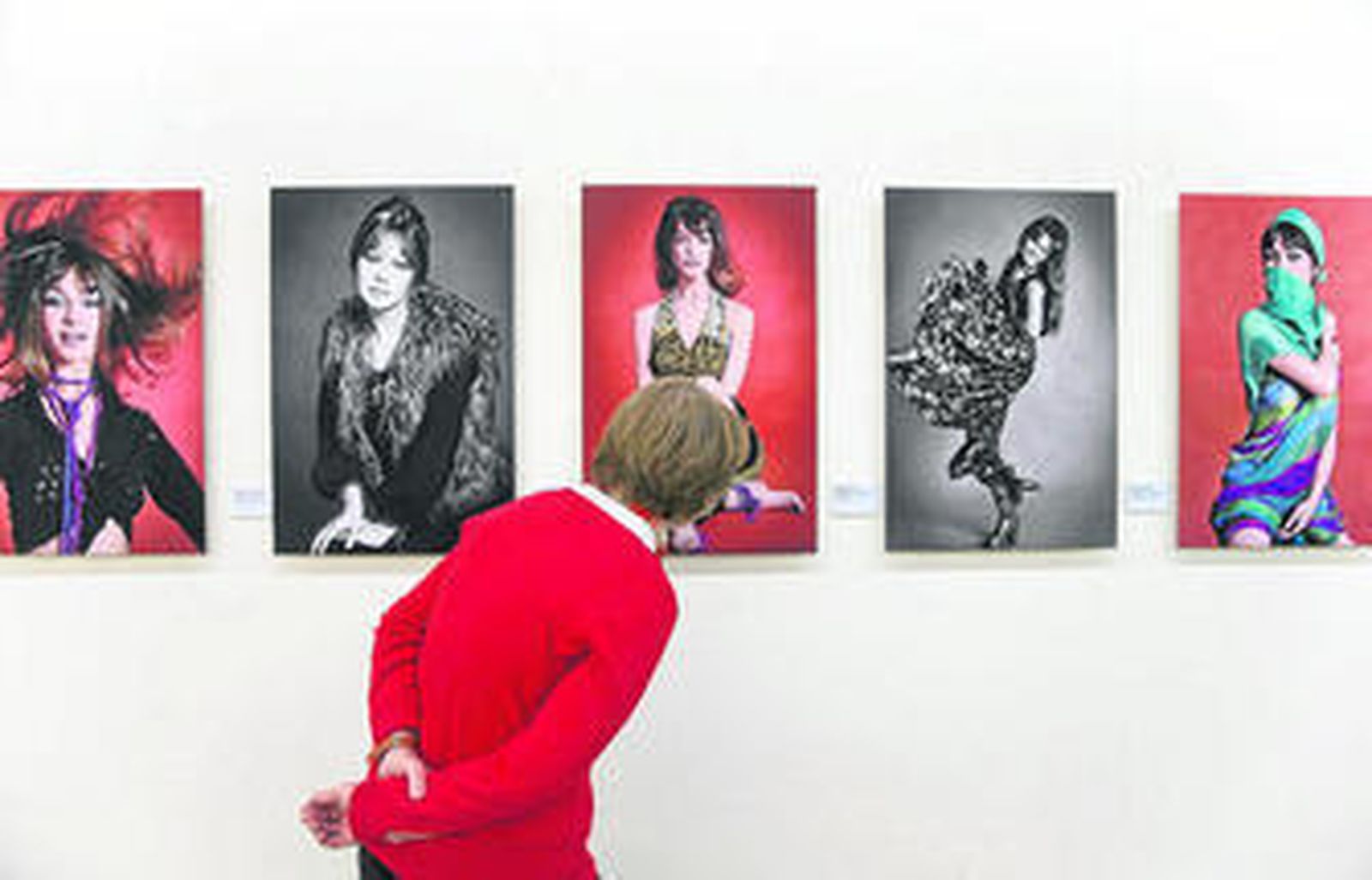 Una mujer observa algunas de las fotografías de la exposición 'El resplandor de un mito'.