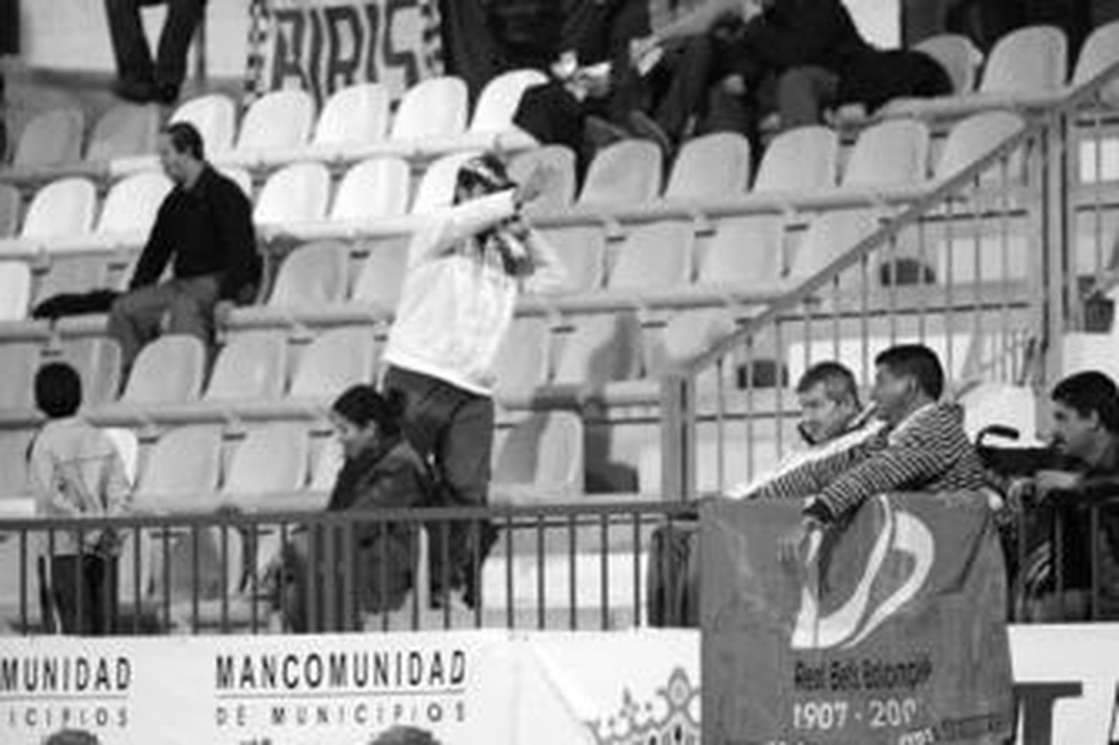 1. Un aficionado sevillista increpa a varios espectadores situados junto a una bandera del centenario del Betis, el eterno rival del equipo hispalense. En la parte superior de la imagen aparece una pancarta de los Biris, el grupo ultra sevillista. 2. Los jugadores del Granada 74 saltaron al campo con una camiseta de ánimo para el sancionado por dopaje Borja Criado, que estuvo presente en el partido. /REPORTAJE GRÁFICO: SALVADOR RODRÍGUEZ