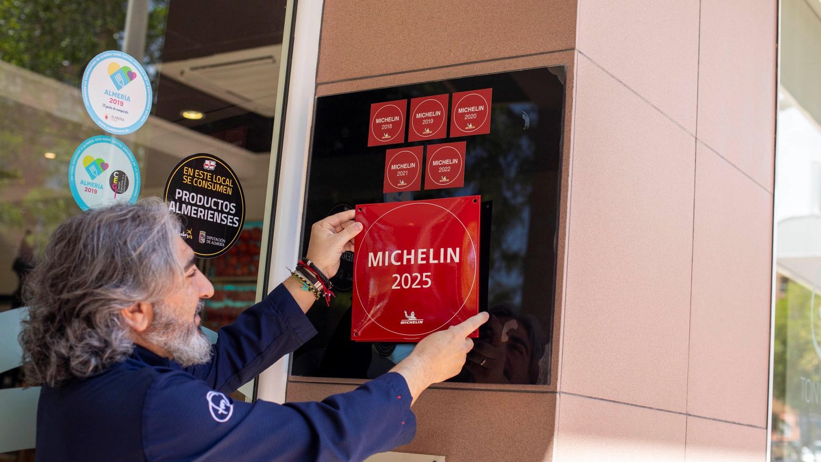Tony coloca el cartel de 'Guía Michelín 2025'.