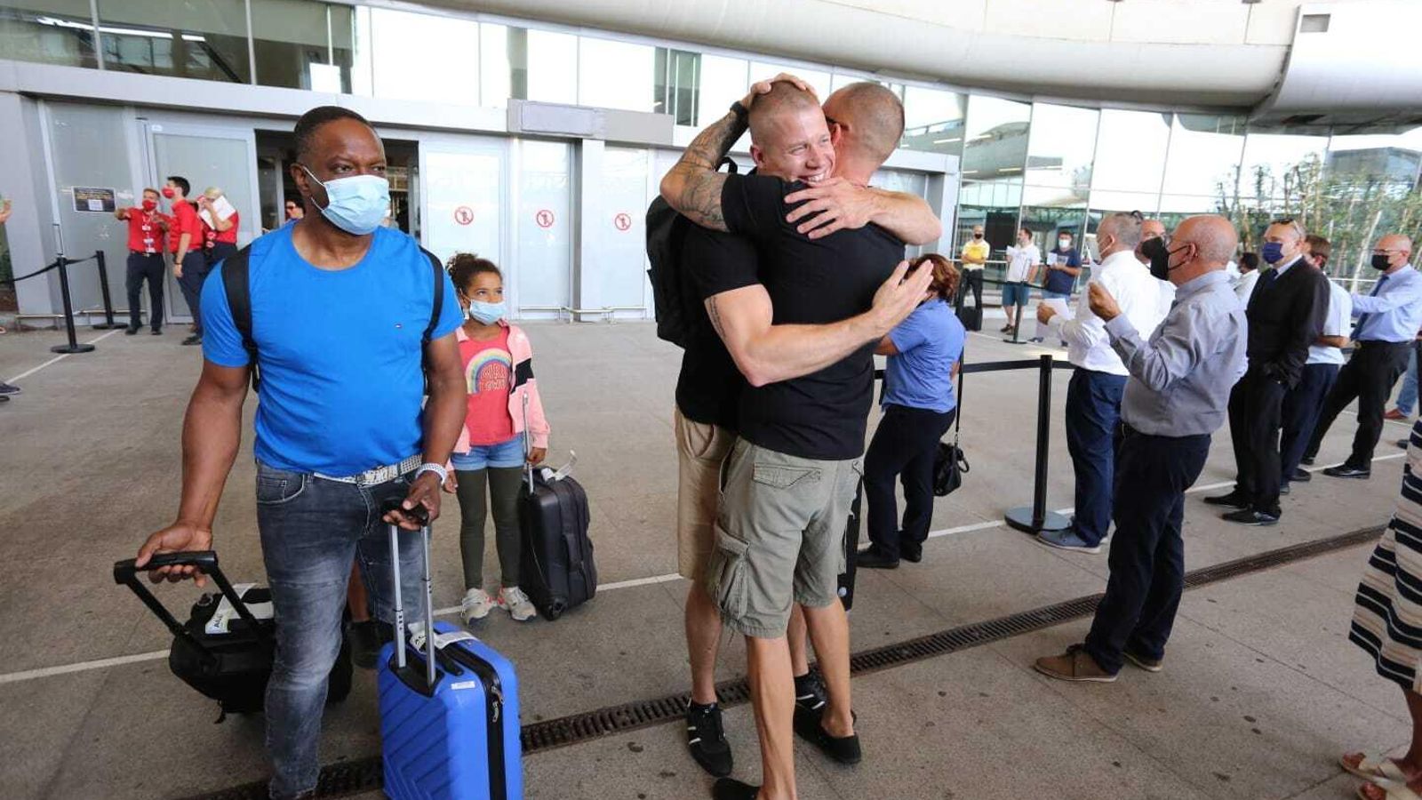 Dos amigos se abrazan a la llegada de uno de ellos al aeropuerto.