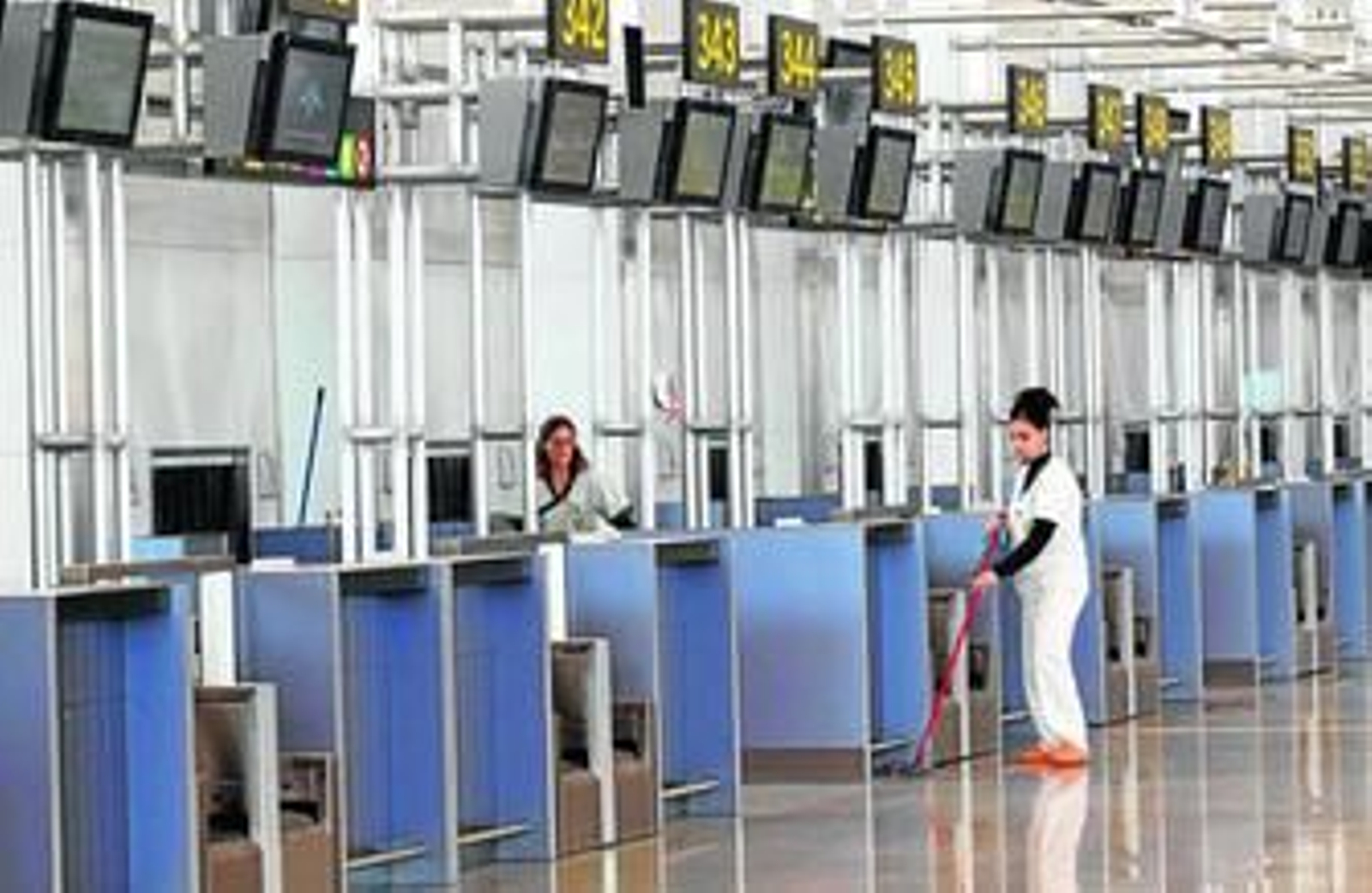 Dos limpiadoras, ayer, dan un repaso a varios de los nuevos mostradores de facturación. Dos limpiadoras, ayer, dan un repaso a varios de los nuevos mostradores de facturación.