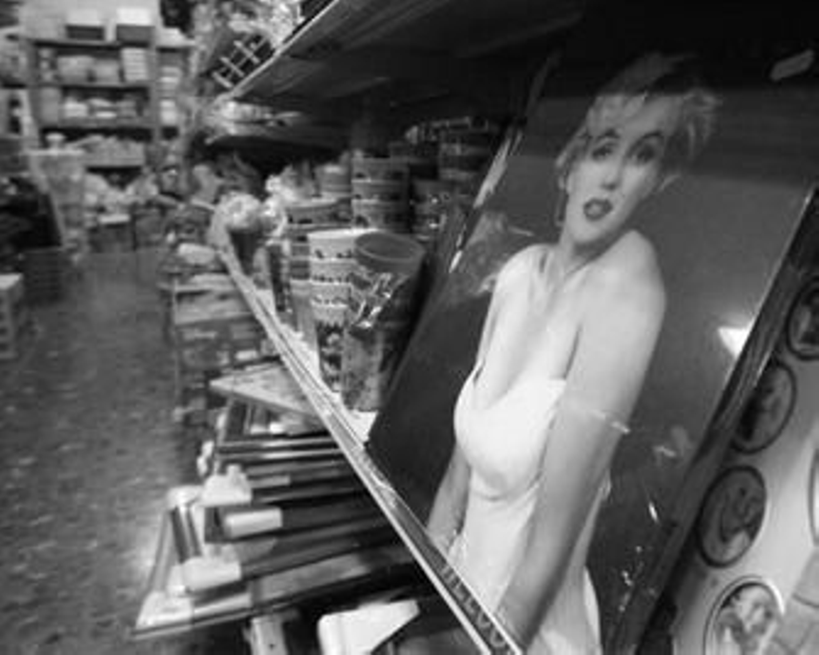 Una lámina de Marilyn Monroe junto a otros productos en una estantería de un bazar de La Línea.